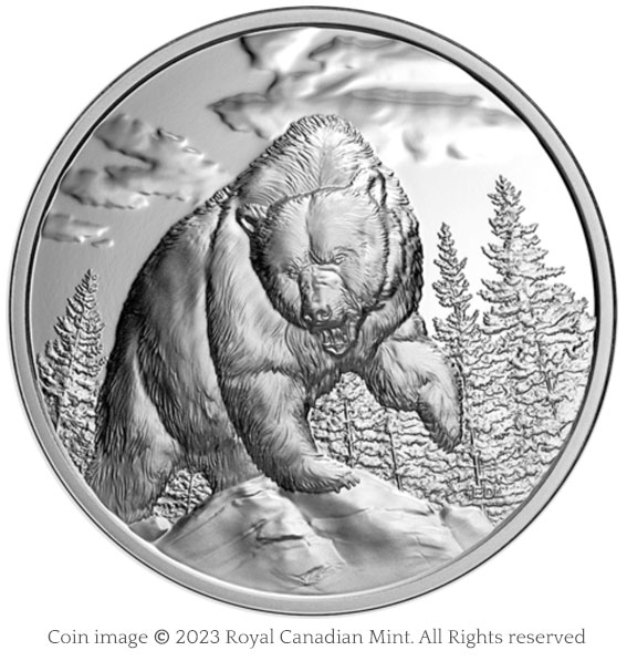 image of silver coin featuring a grizzly bear standing on a rock with one paw raised and teeth bared